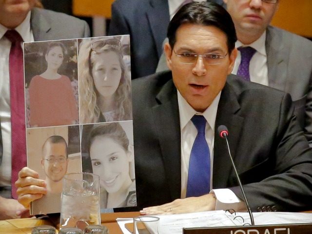 Israel U.N. Ambassador Danny Danon display pictures of four victims of a recent attack in Israel, as he speaks during a Security Council debate on the Middle East conflict Tuesday, Jan. 17, 2017. (AP Photo/Bebeto Matthews)