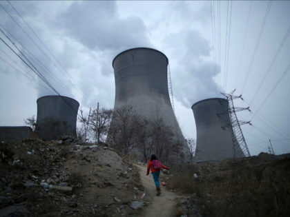 A girl makes her way to her house which locates next to cooling towers of coal-fired power plant in Shijiazhuang, Hebei province, China, January 28, 2015. REUTERS/Kim Kyung-Hoon