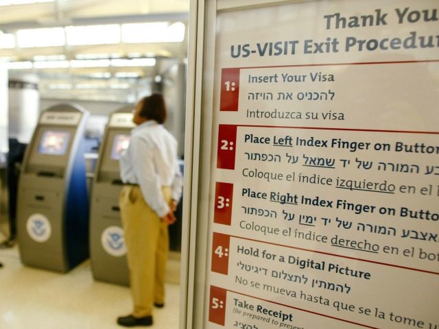 A sign outlines the procedure on how to use the US-VISIT as Carmen Moreno (L) and Joan Walker (C), employees of the U.S. Department of Homeland Security, stand by the newly installed kiosks which scans passports and fingerprints, a biometric procedure that is required of all foreigners exiting Newark Liberty …