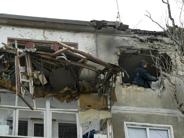 A municipal worker inspects damage to a home after shelling in the city of Donetsk, easter