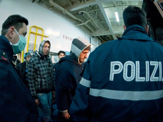 Italian Police escort would-be migrants believed to be from North Africa as they are disem