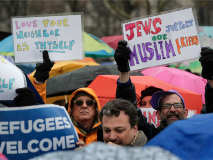 Demonstrators hold up signs during a rally in Battery Park organized by the Hebrew Immigra