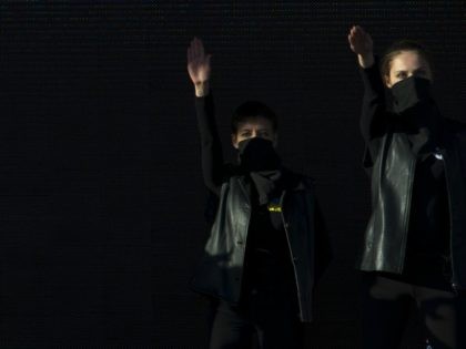 Performers playing the Ukrainian 'Fascists' (R) make Nazi salutes during a balle