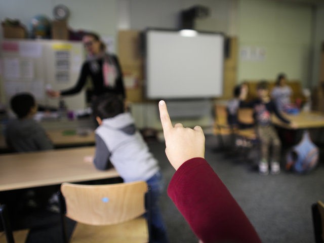 In this Tuesday, Oct. 6, 2015 photo a child rises her hand to answer a question of teacher Sandra Wiandt, background, at a so-called Willkommensklasse (Welcome Class) at the elementary school at the Baeke in Berlin, Germany. As a new school year began last month, Berlins schools saw non-German speaking …