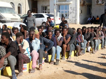 Illegal migrants sit in a port in Tagiura, east of the Libyan capital Tripoli, after 137 migrants of African origins were rescued by coast guard boats off the coast of Libya on July 21, 2016. / AFP / STRINGER (Photo credit should read STRINGER/AFP/Getty Images)
