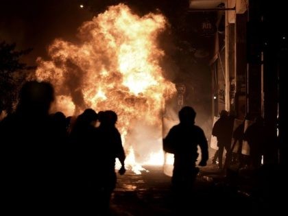 A molotov cocktail thrown by protesters explodes in front of riot police in the central di