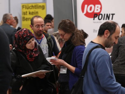 BERLIN, GERMANY - JANUARY 25: A young woman from Syria (L) learns about job opportunities at the second annual jobs fair for refugees and migrants at the Estrel hotel and conference venue on January 25, 2017 in Berlin, Germany. The intiative brings together exhibitors from retail, the service industry, manufacturing, …