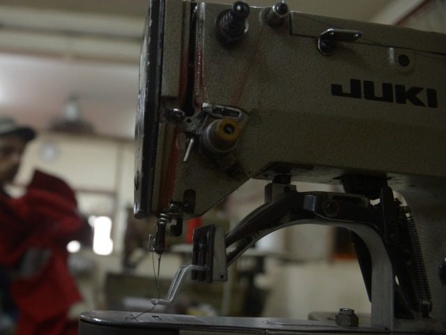 This photo taken on February 7, 2015 shows a Pakistani tailor making shirts at a factory i