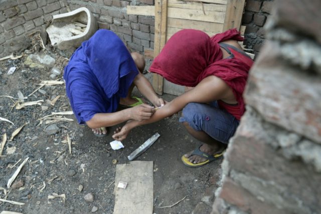 Young Indian drug addicts take heroin in an abandoned building in Jalandhar, Punjab