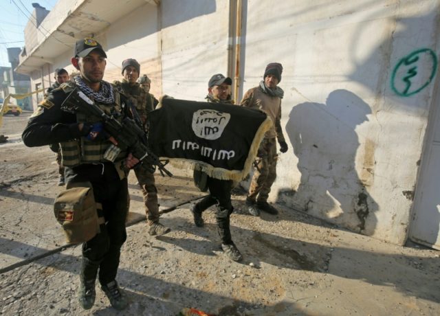Members of the Iraqi special forces Counter Terrorism Service walk with an Islamic State g