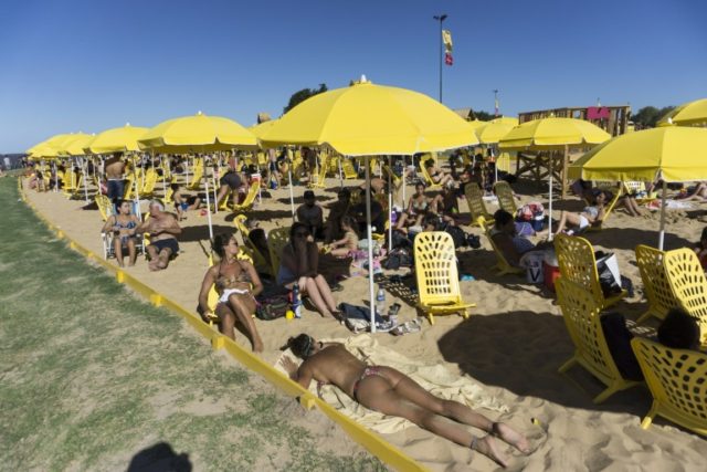 People sunbathe at an artificial urban beach along the Rio de la Plata in Buenos Aires, on