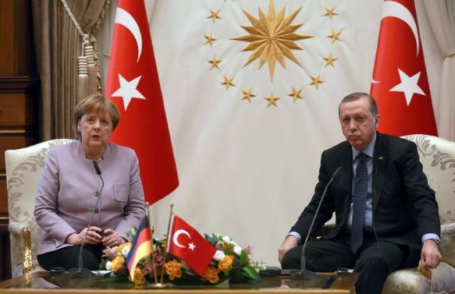 Turkish President Recep Tayyip Erdogan (R) listens on as German Chancellor Angela Merkel s