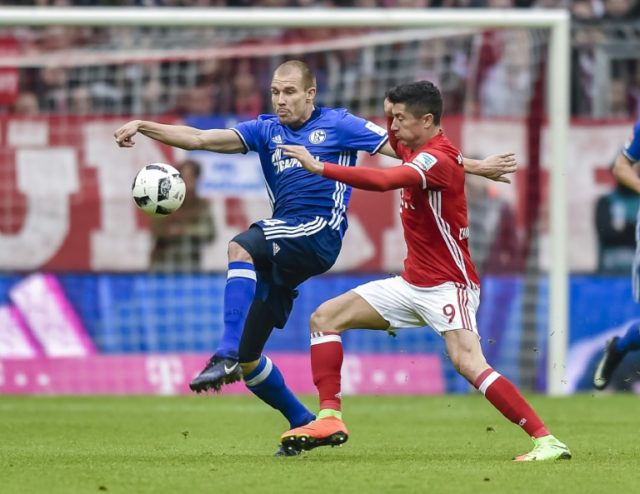 Schalke's Holger Badstuber (L) fights for the ball with Bayern Munich's Robert Lewandowski