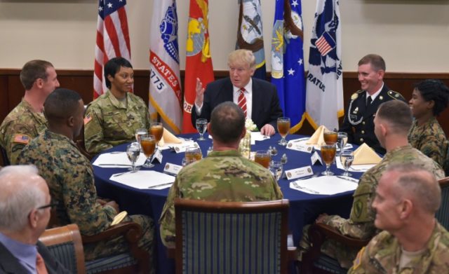 US President Donald Trump sits down for lunch with troops during a visit to the US Central