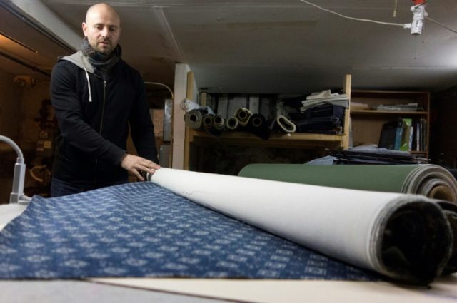 Former investment banker Eric Steffen rolls out fabric at his workshop in the borough of B