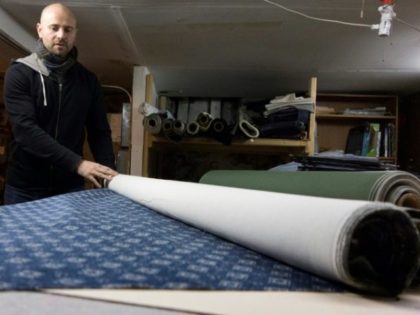 Former investment banker Eric Steffen rolls out fabric at his workshop in the borough of Brooklyn, New York on February 2, 2017