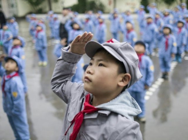 Students attend the flag-raising ceremony at the Yang Dezhi 'Red Army' elementar