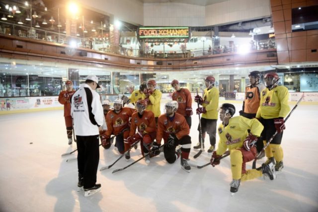 Indonesian ice hockey team players listen to their Malaysian coach Gary Tan (L in white) a