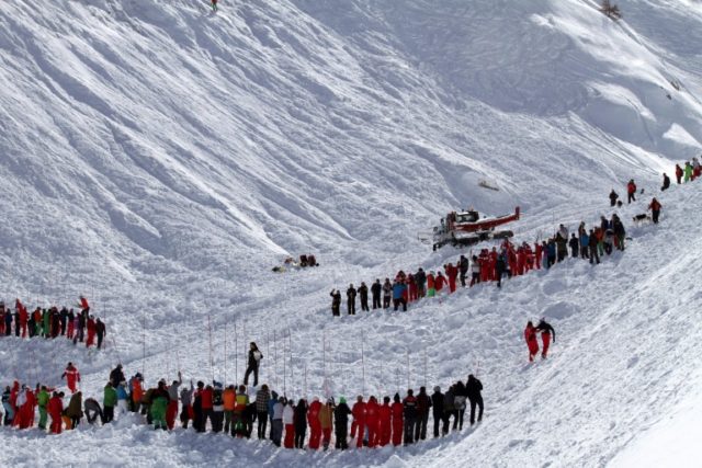 Rescuers work in an off-piste area after an avalanche engulfed nine people, killing at lea