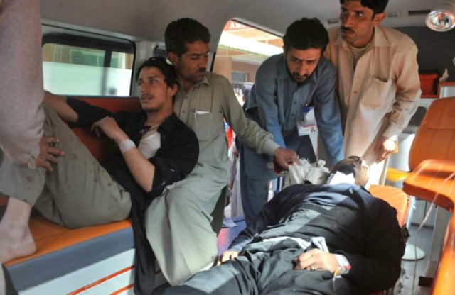 Volunteers transport blast victims to a hospital in Peshawar on February 21, 2017, after t