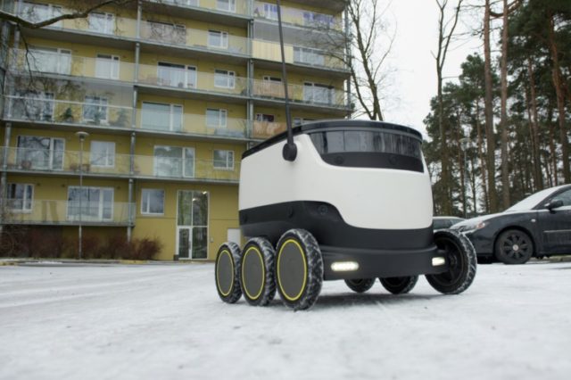 A six-wheeled robot by Starship Technologies makes its way to deliver food from a restaura