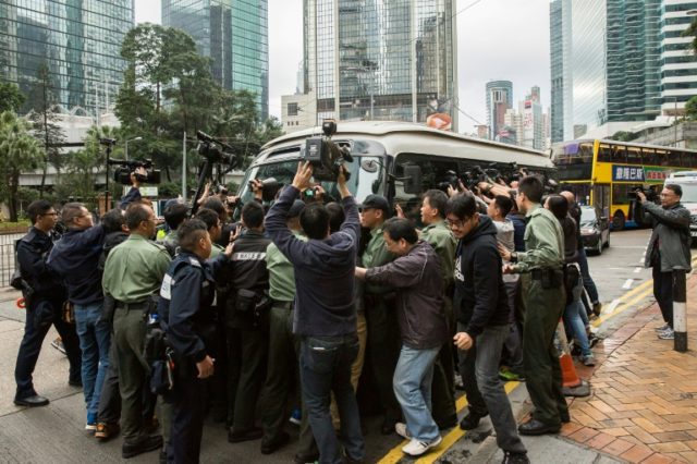 A media scrum greets former Hong Kong leader Donald Tsang as he arrives at court to hear h