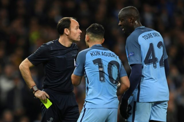 Manchester City midfielder Yaya Toure (R) and striker Sergio Aguero (C) remonstrate with t