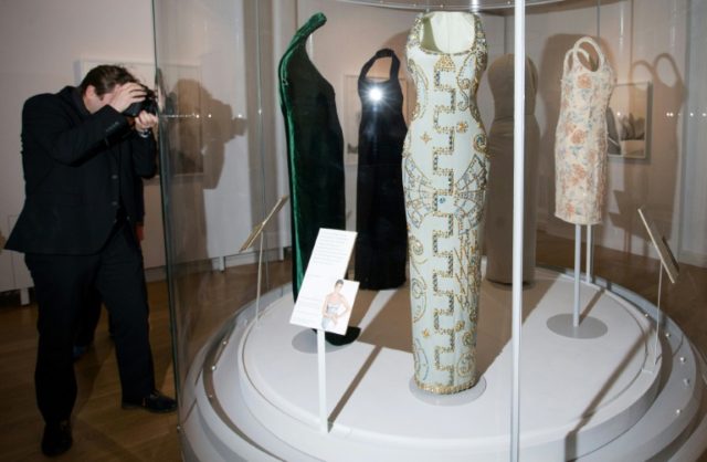A photographer takes pictures of dresses worn by Britain's Diana, Princess of Wales, durin