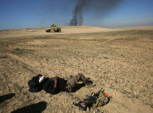 An Iraqi soldier waits to be evacuated, after he was wounded in an explosives-laden vehicl