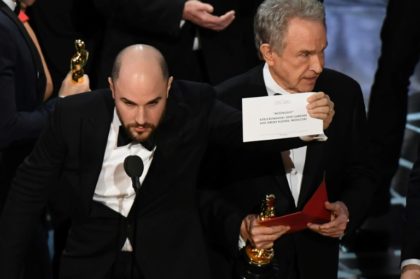 "La La Land" producer Jordan Horowitz (L) holds up the card reading Best Film 'Moonlight"
