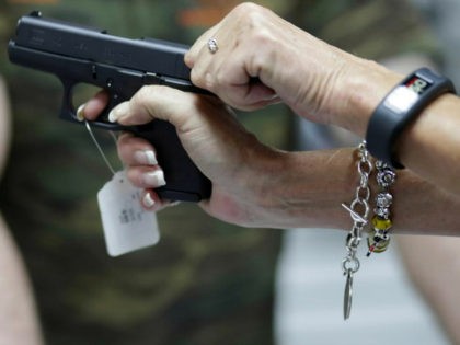 Sally Abrahamsen, of Pompano Beach, Fla., right, holds a Glock 42 pistol while shopping for a gun at the National Armory gun store and gun range, Tuesday, Jan. 5, 2016, in Pompano Beach, Fla. President Barack Obama unveiled his plan Tuesday to tighten control and enforcement of firearms in the …