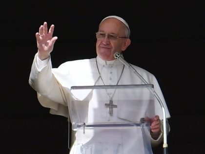 Pope Francis waves to the crowd from the window of the apostolic palace during the Sunday