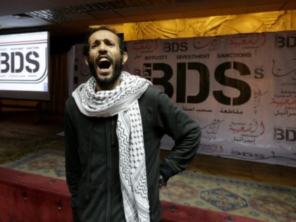 An Egyptian shouts anti-Israeli slogans in front of banners with the Boycott, Divestment and Sanctions (BDS) logo during the launch of the Egyptian campaign that urges boycott, divestment and sanctions against Israel and Israeli-made goods, at the Egyptian Journalists’ Syndicate in Cairo, Egypt, Monday, April 20, 2015. BDS is a …