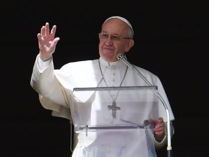 Pope Francis waves to the crowd from the window of the apostolic palace during the Sunday