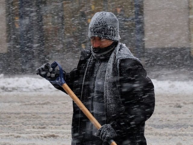 A man cleans snow from a street during a winter storm in New York on February 9, 2017. A