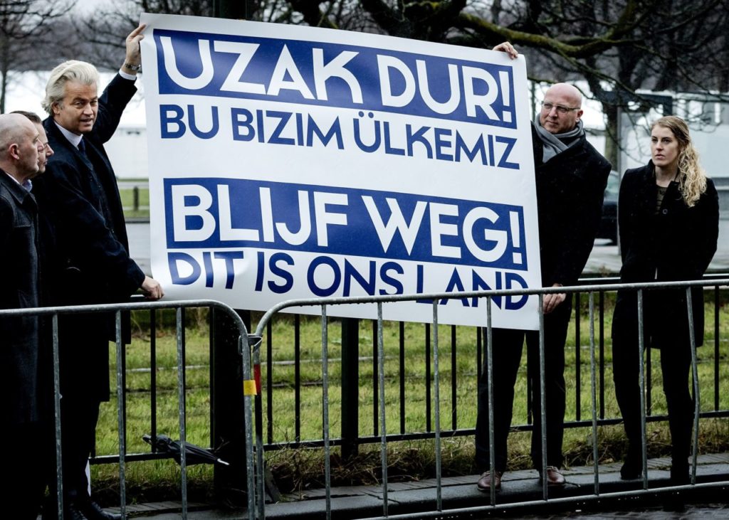 Dutch far-right Freedom Party leader (Partij Voor De Vrijheid, PVV) Geert Wilders (L) holds a banner reading "Get out! This is our land" during demonstration in front of the Turkish embassy at The Hague on March 8, 2017. Wilders protested against the Turkish government intention to campaign in the Netherlands in favor of the referendum on the Turkish constitutional changes. The Dutch parliamentary elections are set to take place on March 15 with Wilders and his far-right PVV Party leading the polls. / AFP PHOTO / ANP / Robin van Lonkhuijsen / Netherlands OUT (Photo credit should read ROBIN VAN LONKHUIJSEN/AFP/Getty Images)