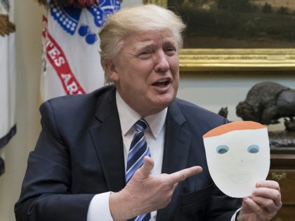 WASHINGTON, DC - MARCH 13: President Donald Trump holds up a note and drawing depicting hi