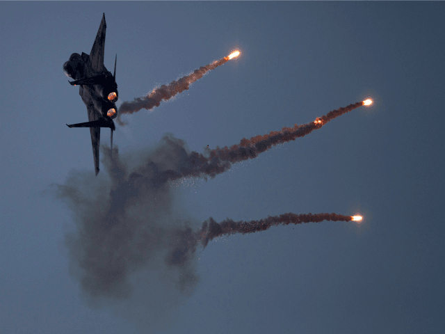 An Israeli Air Force fighter jet releases flares during an acrobatics display during a graduation ceremony in the Hatzerim air force base near the southern city of Beersheba, Israel, Thursday, Dec. 27, 2012. (AP Photo/Ariel Schalit)