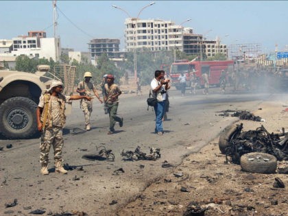 Soldiers gather at the site of a car bomb attack in a central square in the port city of A