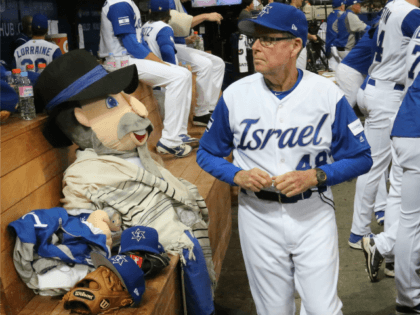 Israel's third base coach Pat Doyle, right, passes by his team mascot, The Mensch on