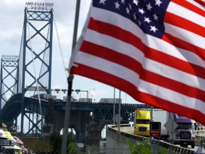 trucks head to US customs after crossing the Ambassador Bridge that connects Detroit, Mich