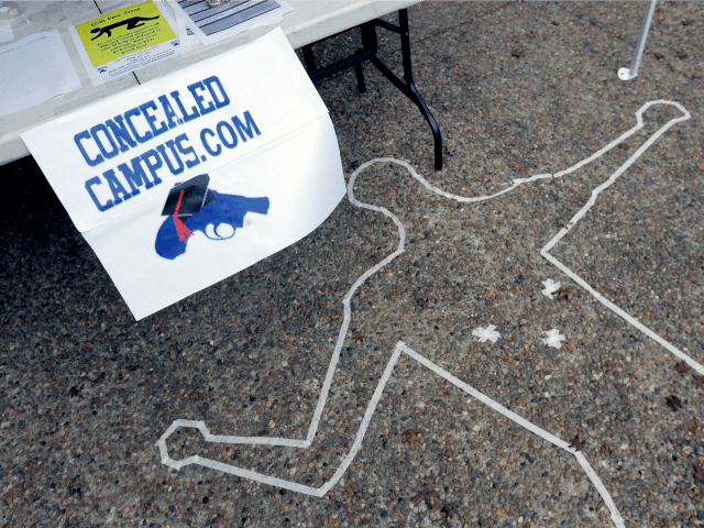 Signs and a replica of a crime scene draw attention to a booth on the campus of Texas Stat