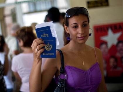 A woman shows her passport and that of her son to reporters as she leaves an immigration o