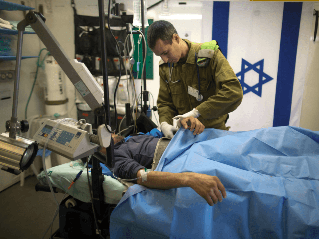 Israeli military medic tends a Syrian man who was wounded in the ongoing violence in Syria