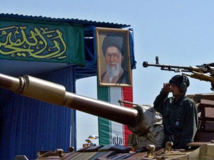 In front of a picture of supreme leader Ayatollah Ali Khamenei, Iran's elite Revolutionary Guards' members, salute atop their tank, during a parade ceremony, marking the 24th anniversary of the outset of the Iran-Iraq war (1980-1988) in front of the mausoleum of the late revolutionary founder Ayatollah Ruhollah Khomeini, just …