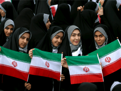 Young women hold national flags during an annual rally commemorating the anniversary of the 1979 Islamic revolution, which toppled the late pro-U.S. Shah, Mohammad Reza Pahlavi, in Tehran, Iran, Friday, Feb. 10, 2017. (AP Photo/Ebrahim Noroozi)