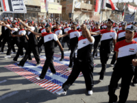 In this Thursday, May 26, 2011 file photo, militiamen loyal to cleric Muqtada al-Sadr march over the American flag while wearing shirts bearing the Iraqi flag in the Sadr City district of Baghdad, Iraq. Shiite militias backed by Iran have ramped up attacks on U.S. troops in Iraq, making June …