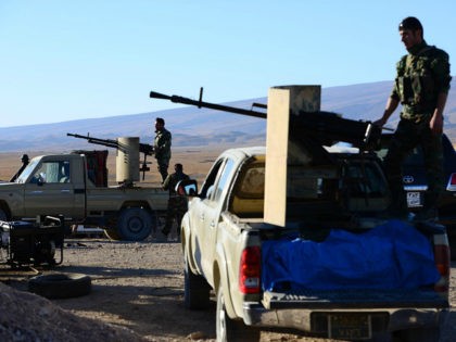 MOSUL, IRAQ - NOVEMBER 22: Peshmerga forces in Sinjar town look on as Daesh terrorists run