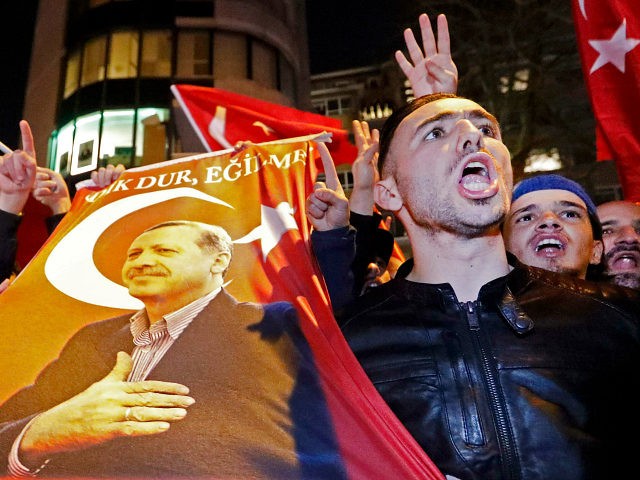 Demonstrators with banners of Turkish President Recep Tayyip Erdogan gather outsidethe Tur