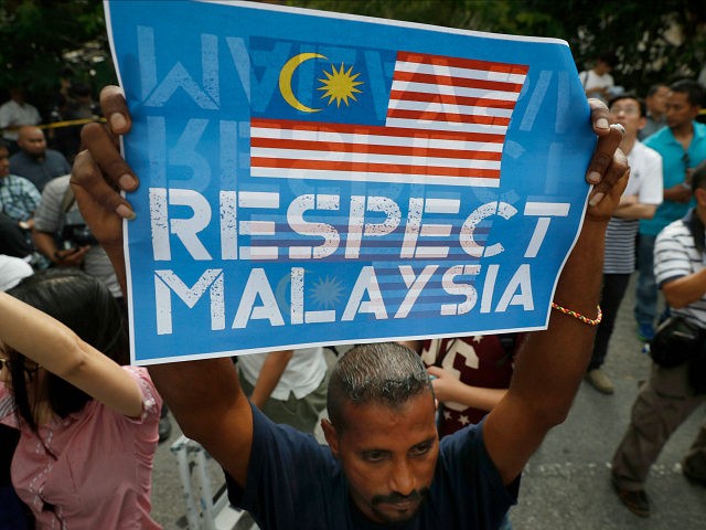 A members of the UMNO (United Malays National Organization) Youth holds up a placard as th
